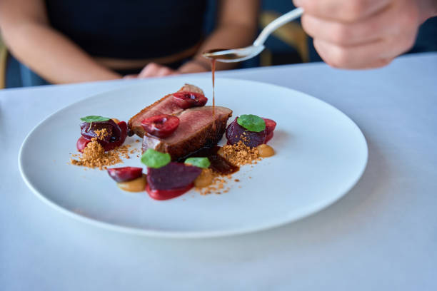 istock Waiter covering beef meat with sauce for lady in restaurant 2178561897