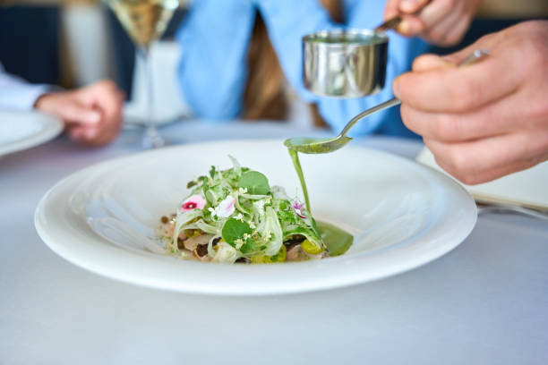 istock Waiter completing a gourmet dish for women in restaurant 2178562038