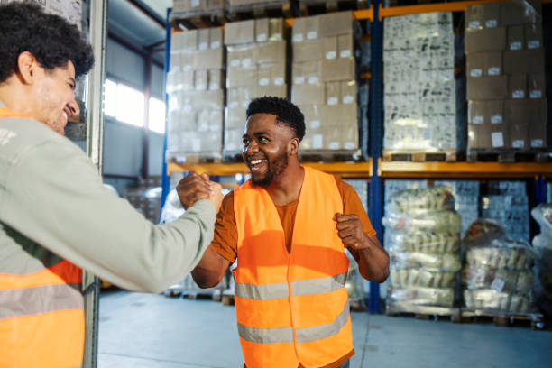 istock Multicultural storage manager shaking hands with blue collar worker and welcoming him. 2178563967