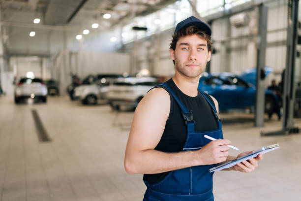istock Professional supervisor mechanic male in uniform inspecting repair work checklists with tablet at garage, confident looking at camera. Concept of service car maintenance 2178564919