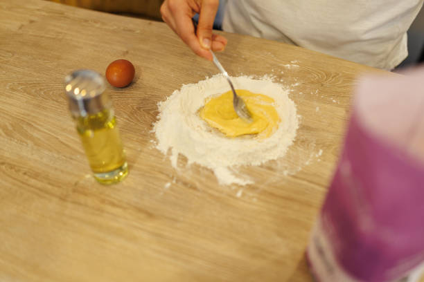 Beating eggs, preparing homemade lasagna dough