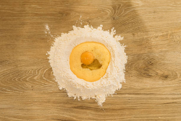 Spreading flour on table, preparing to make dough at home