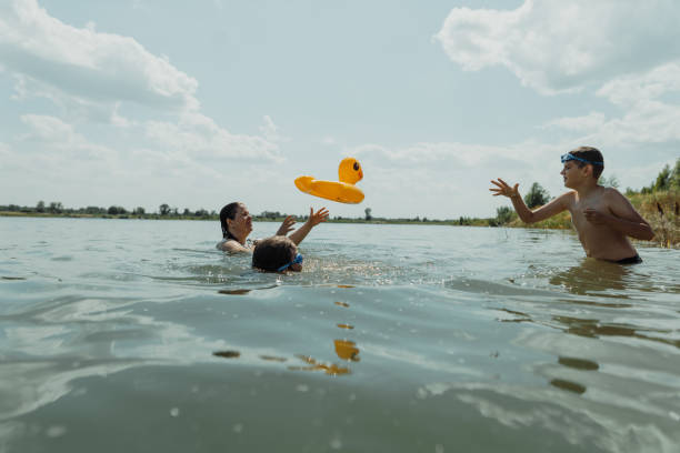 istock Family playing with inflatable duck float in the lake on a sunny day 2178565528