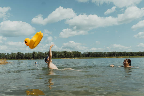istock Summer fun at the lake: family tossing inflatable duck float 2178565628