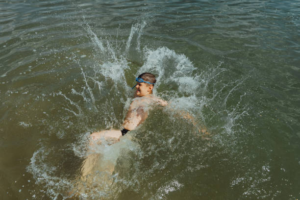 istock Boy splashing in the lake on a sunny summer day 2178565771