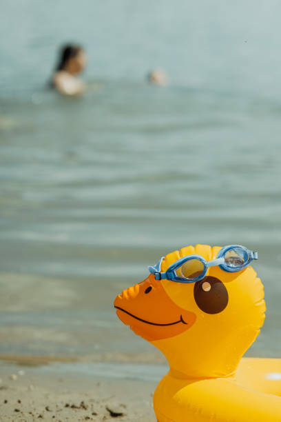 istock Yellow duck float with swimming goggles on the beach 2178565880