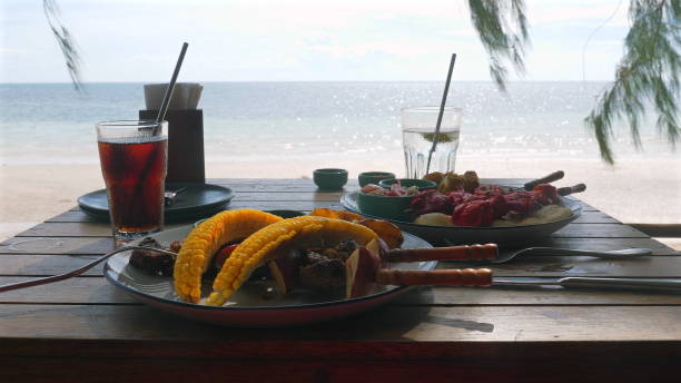 istock Summer beachside dining setup with iced drinks and grilled food, 2178571836