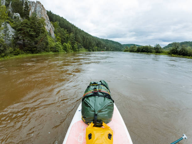 istock A kayaker peacefully paddles in a serene river surrounded by green trees and a clear blue sky, enjoying the tranquil natural setting during their journey in the fluvial landforms of streams 2178573177