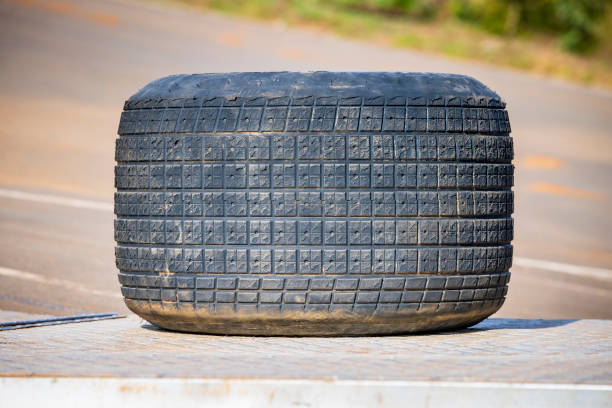 Photograph of a large treaded rubber tyre from a Speedway racing car sitting on the tail gate of a transport hauler.
