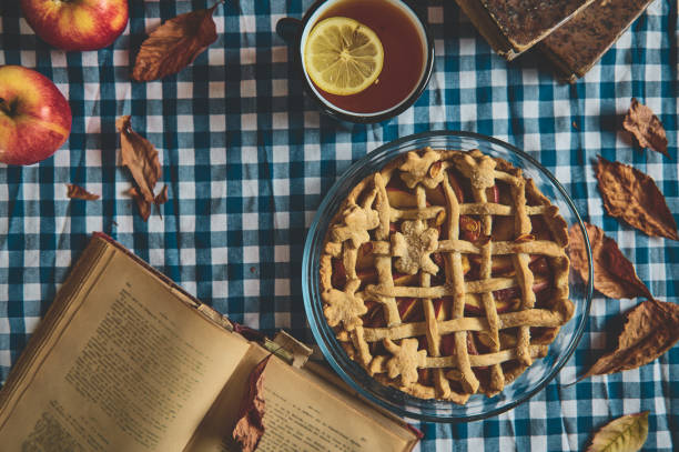 istock Rustic apple pie on checkered tablecloth with autumn leaves and open book for cozy autumn vibes 2178580886