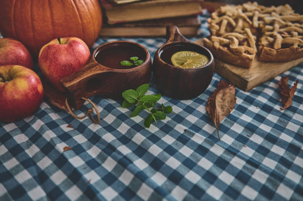 istock Autumn harvest table setting with apples, pumpkin, apple pie, and warm drinks on a blue checkered tablecloth for a cozy and seasonal celebration 2178580906