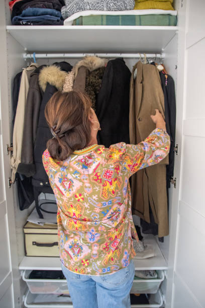 istock Person Looking For A Jacket Inside A Wardrobe Filled With Different Outerwear Options And Accessories 2178583074