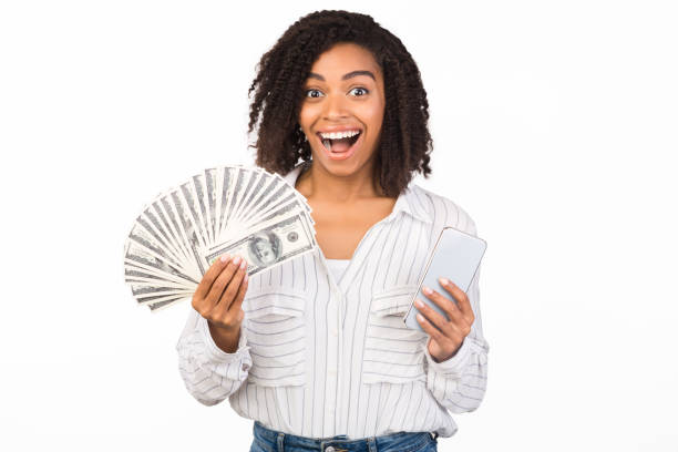 istock Happy black woman holding money and iPhone 11 pro max 2178583988