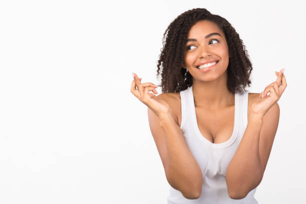 istock Curly afro girl keeping her fingers crossed 2178584005