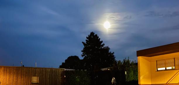 Moon above houses at nightfall