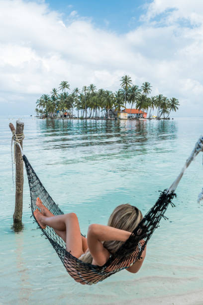 Vertical photo with copy space of a woman lying on an hammock in an idyllic tropical beach
