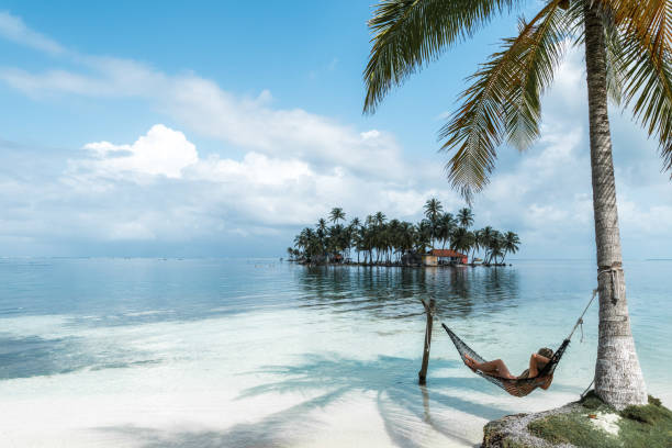 Copy space of a woman lying on an hammock in an idyllic tropical beach