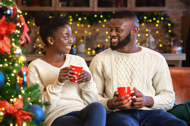 istock Smiling afro couple drinking hot chocolate, celebrating Cristmas at home 2178587085