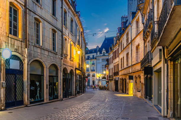 Rue Forges pedestrian street in Dijon city historical centre with stores, shops and old typical houses buildings, Dijon old town on twilight dusk evening view, Bourgogne-Franche-Comte region, France calle peatonal rue forges en el centro histórico de la ciudad de dijon con tiendas, tiendas y edificios de casas típicas antiguas, casco antiguo de dijon en la vista nocturna del crepúsculo del crepúsculo, región de borgoña-franco condado, francia