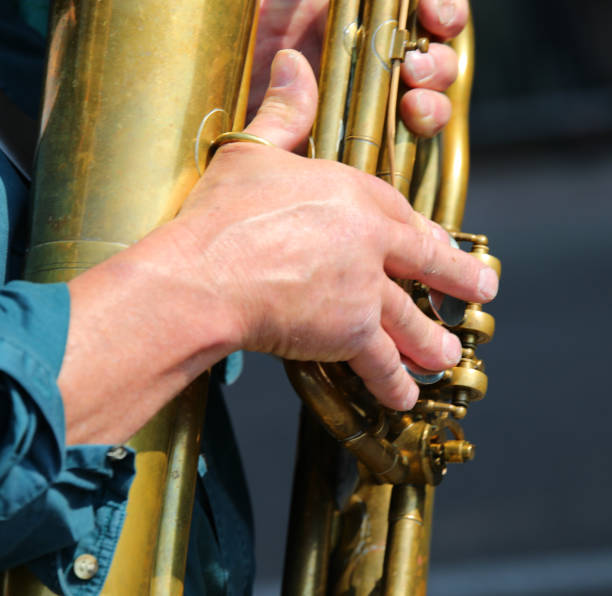 istock hands of the player while setting the notes on the brass wind instrument during the performance 2178588869