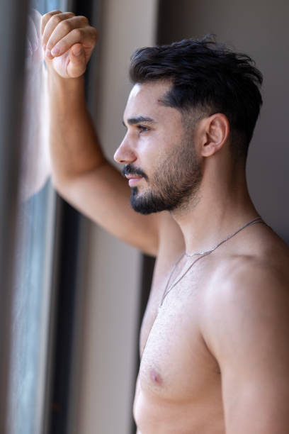 Portrait of handsome muscular man looking out window
