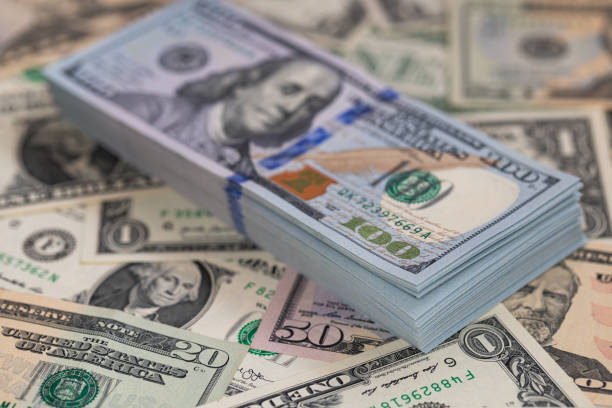 istock Pile of US 100 dollar banknotes on dollars background 2178591011