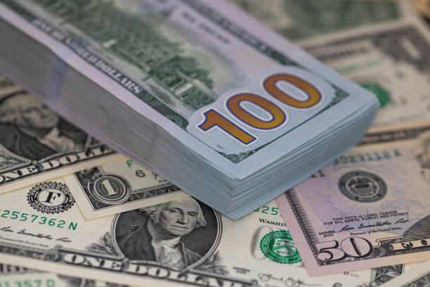 Pile of US 100 dollar banknotes on dollars background for design purpose