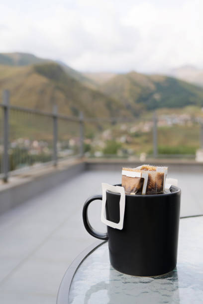 Drip coffee bag with ground coffee in cup. Making freshly coffee in mug.