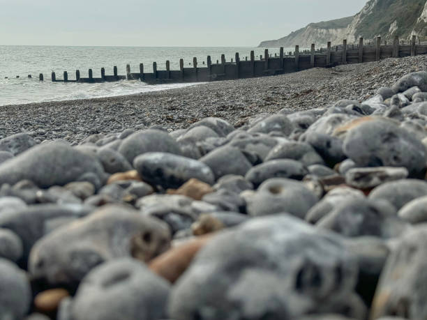 DISTANT FOCUS (one of three).  The pebble beach and breakwaters at the Holywell end of Eastourne, East Sussex, UK, a resort town photographed in the off season (October).