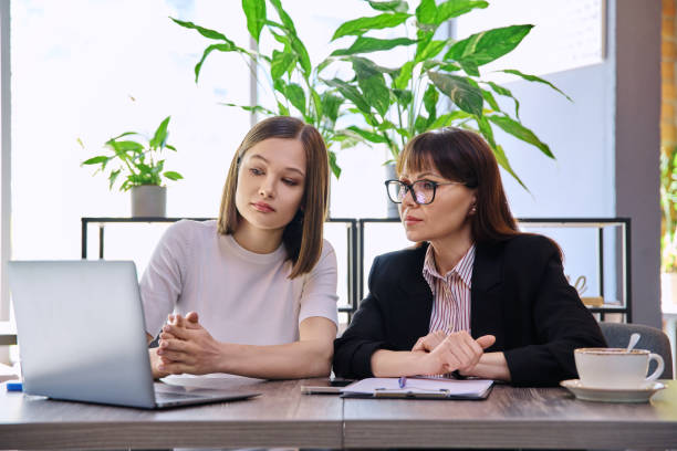 istock Two women sitting at table in coworking space with laptop 2178597918