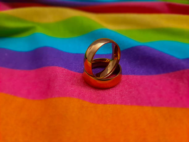 istock Gay pride rainbow flag and gold wedding rings. 2178598354