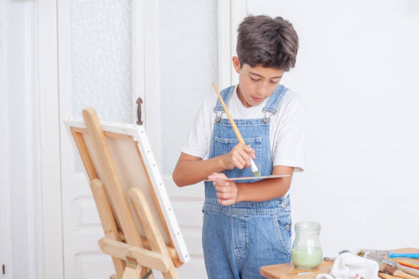 istock A young boy is painting a picture on a canvas 2178599327