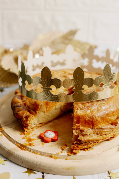 One cut royal galette with a crown and a surprise gift on the table.