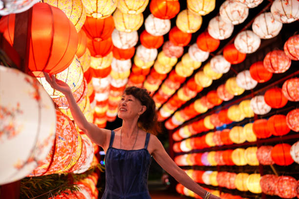 Senior woman under colorful lanterns