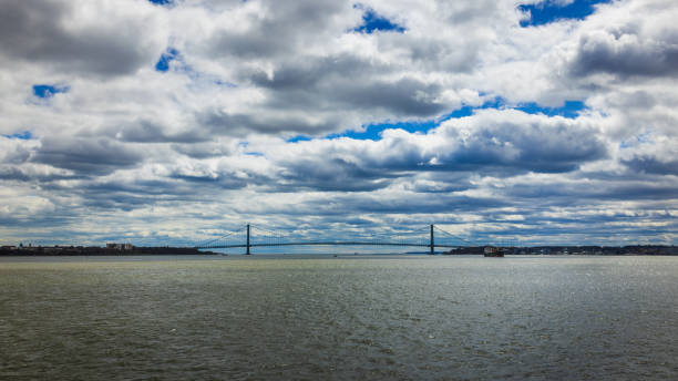 The Verrazzano-Narrows Bridge stretches across the New York Bay under a dramatic sky, connecting boroughs with its expansive steel structure.
