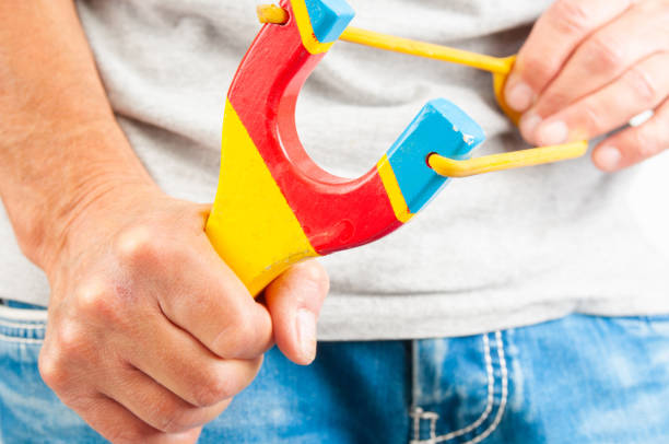 Child playing with a slingshot in the garden: aiming high and having fun