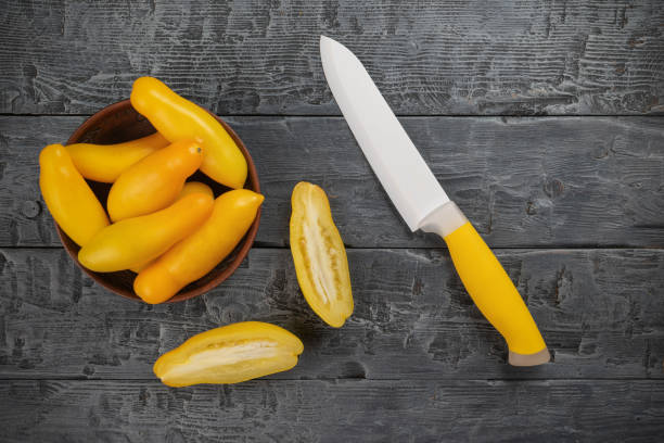Yellow Cucumbers and Knife on Rustic Wooden Surface: Fresh Produce and Culinary Tools