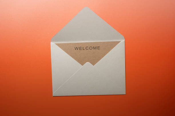 Top view of white envelope and postcard with brown card with words \