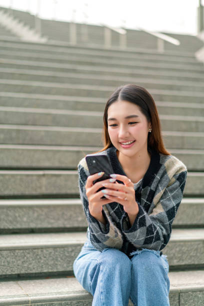 istock Gen Z Young Woman Using Phone Outdoors 2178636503