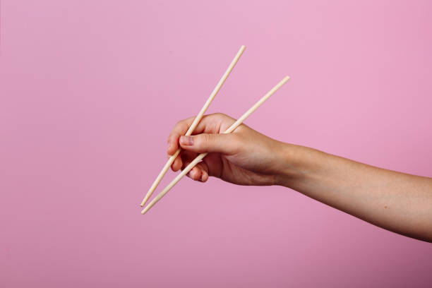 istock Hands holding chopsticks. Isolated on pink background, the place for caption and text 2178639175