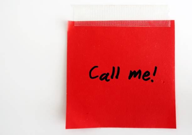 A red note with text written CALL ME ,on white background. Concept of telling someone to make a phonecall.