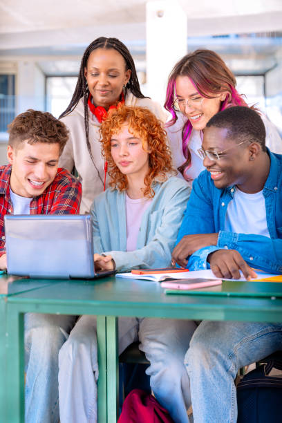 istock A group of students with laptops sit near the campus and communicate.Vertical 2178643901