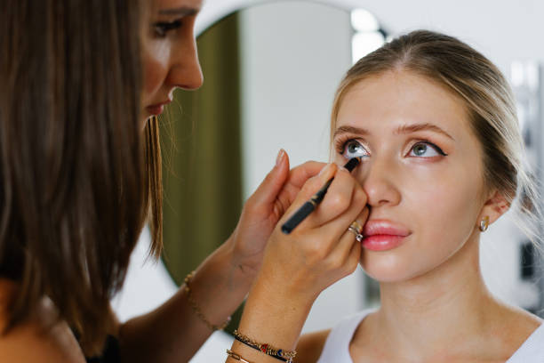 istock Makeup artist makes makeup for a young woman, draw arrows on her eyelids 2178644564