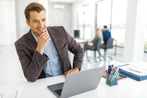 istock Happy businessman working on laptop at corporate office. 2178646323