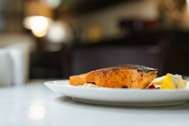 Grilled salmon fillet served on a plate with a blurred background.
