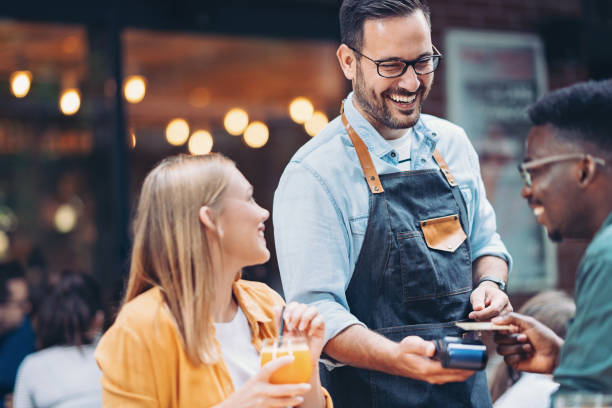 istock Cheerful waiter accepting a credit card payment in a restaurant 2178653750