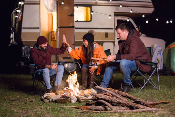 istock Group of close friends around camp fire laughing 2178658155