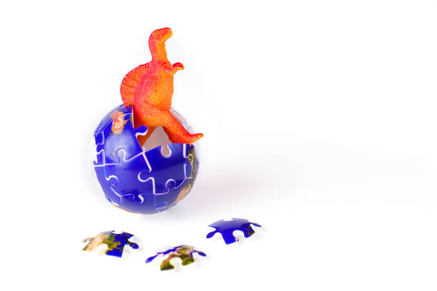 A boy interacts with plastic dinosaurs and action figures at a table, engaged in a fantasy world during creative solo play.