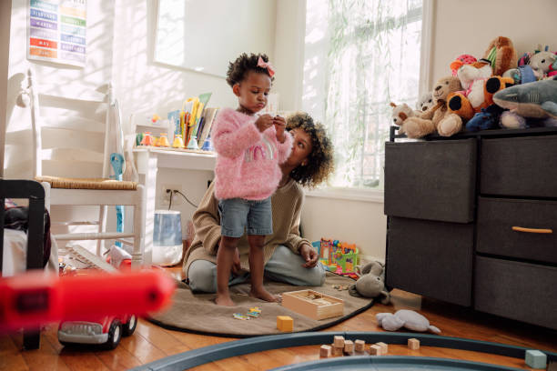 istock Mother and daughter playing together on bedroom floor 2178658751