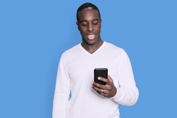 istock Man smiling at phone in white sweater 2178660096